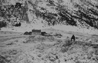 Alfred Stokkebø sit oppå snømassane som skreda la frå seg på vegen mot fjorden. Her ser me mot stovehuset på bruk nr. 1 frå indre Ese på den andre sida av elva.