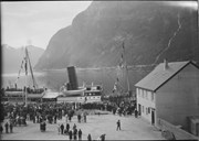 ds «Nordfjord 1» på pinsetur. 17. mai 1932, ca klokka 10. Båten ligg til kai i Høyanger. På framdekket Mannssangforeningen «Freya», på promenadedekket Lungegårdens Musikkorps.