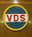 MS «Lofoten» har fleire historiske gjenstandar frå DS "Lofoten", Vesteraalens Dampskibsselskab (VDS) sitt hurtigruteskip i 32 år, frå 1932 til 1964. Denne baugrosetten frå DS "Lofoten" er «utstilt på vegg» i akterskipet.