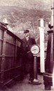 Kaptein i Fylkesbaatane, Heinrich Wilhelm Wærness (1869-1945), her på brua på ein amtsbåt/fylkesbåt, kan henda ds «Fjalir». På skipsklokka kan ein skimta bokstavane FJA.