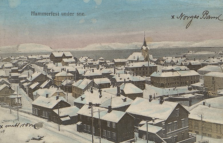 Anders Skaasheim budde i Hammerfest frå desember 1921 til november 1922. Dette postkortet, datert 11.12.1921, med motiv Hammerfest sende han til far sin, Christen Skaasheim, Balestrand. Han har sett kryss ved pensjonatet han budde og Norges Bank, avdeling Hammerfest, der han arbeidde.