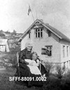 17. mai 1946. Hanna Skagen og barnebarnet Ingris Senneseth. Ingrid har flagg og dei "har heist flagget" på flaggstang ut gjennom loftsglaset.