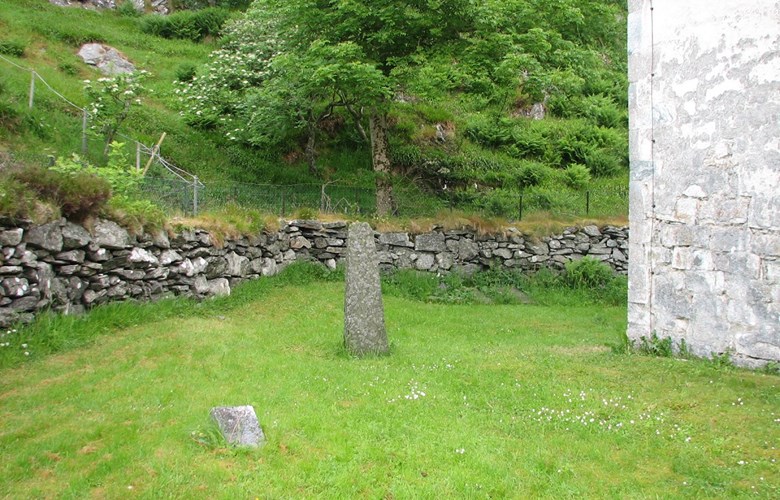 Minnesteinen på fellesgrava til gravlagde som vart funne under kyrkjegolvet i 1911. Steinen står ved det nordvestre hjørna på kyrkja.