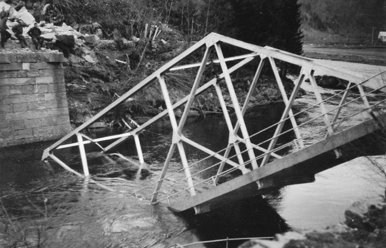 Osen bru nedramla i elva etter arbeidsuhell 28. april 1959. Fire personar er synlege på brukaret. Brua vart bygd i 1925.
