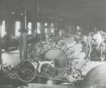 Eli Drageset ved kardeverket. I fabrikkbygningen var det fire sett kardemaskiner, fire spinnemaskiner, ni vevstolar og mykje utstyr til bruk ved farging, stamping og overskjering.