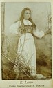 Serine Rasmusdotter Maurstad (f. 1882) frå Bremanger fotografert i nasjonaldrakt i ein kunstig skog i Lexau sitt fyrste atelier i Bergen.