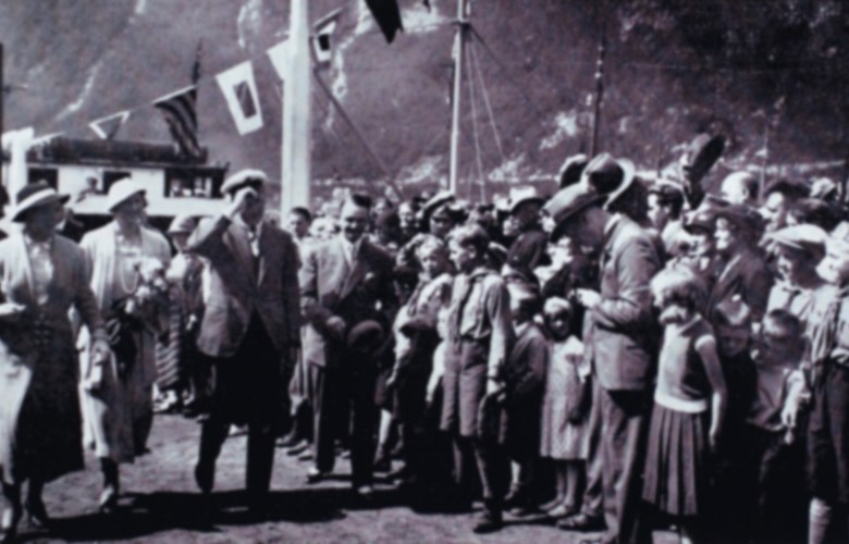 Kronprinsparet i Høyanger, pinsehelga 1933. Flaggsmykka MS "Nesøy" ligg til kai.