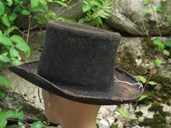 Denne hatten er laga av filt. Filt har vore nytta mellom anna til hovudplagg og sko. NFM.1988-00207.