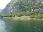 Fronnes sett frå fjorden. Elva og fossane er lettast å oppleve på land.
 