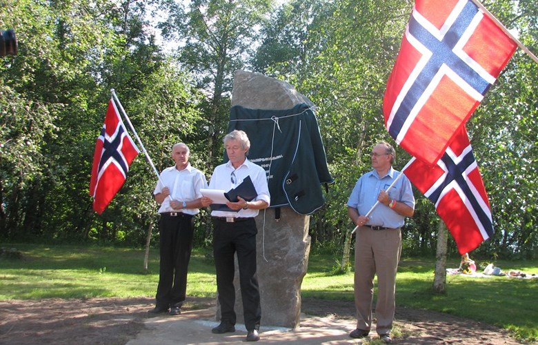 Frå avdukinga, fredag 4. juli 2008. Henning Rivedal held avdukingstale. Per Birger Lomheim (Statens vegvesen, til venstre) og Jostein Bye (Jølster kommune) flankerer steinen.