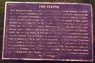 Tekstplata som informerer om The Steine er festa på ein fot sett ned i bakken eit par meter frå minnesteinen.
