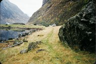 Vegen går gjennom Holmo, eit nes som stikk ut i Nærøyfjorden. Her har det budd folk frå gammalt av. Mot fjorden ligg ei større gravrøys frå bronsealderen. Den er 20 m lang og 14 m brei. Høgda er ca 2,5 m. Gravrøysa er det aller første sporet ein har etter menneskeleg aktivitet i dette området. Det er tydeleg at steinane frå gravrøysa er nytta til husbygging, då ein finn att same type stein i ruinane på stølsvollen. Gravrøysa ligg heilt i venstre biletkant.

