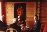 Her er Kong Olav under opninga på Grotli Høyfjellshotel saman med representantar for arbeidarane. Frå venstre er Johan Graff, Oppland, til høgre sit Reidar Fure, Stryn. Mannen med ryggen til er Torstein Treholt, fylkesmann i Oppland.

