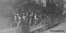 
Her ser vi ein ungdomsgjeng frå veganlegget på Sognefjellet (1936-38), som skal på fest i Jostedalen. Bilen står like utanfor Ottumtunnelen. Vegen er her sprengd inn i fjellet som ein halvtunnel.
