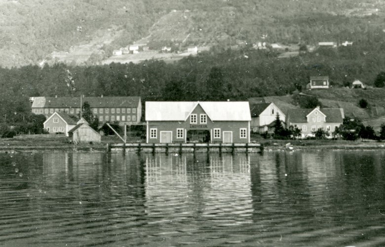 «INDVIKEN». Båtstoppestaden i Innvik med steinbryggje og ekspedisjonsbygning oppsett 1909-1910. I bakgrunnen Innvik Ullvarefabrikk.