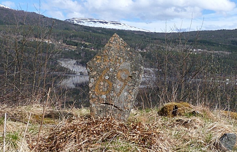 Stein til minne om veg til Kandal. På steinen er måla på 28-10 og 69 (under), 28. oktober 1969, datoen for avlevering av siste vegstykket som gav bygda vegutløysing.