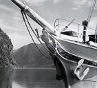 Gallionsfiguren på plass under baugsprydet på d/s «Hornelen». Utsnitt av foto av «Hornelen» til kai i Flåm på 1930-talet.
Datering: 1930 – 1939.