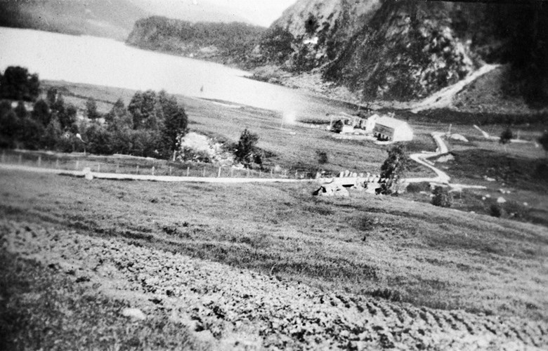 Hovlandsvatnet og Hovlandsgardane rundt 1910. Her ser vi vegen som svingar seg oppover mot Guddalen.