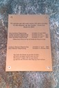 Minnesteinen står i gardstunet, i ein bakke opp mot vegen. På plata er skrive namna på seks personar som utvandra og eit vers Jens Hogrenning skreiv etter eit besøk i Amerika.