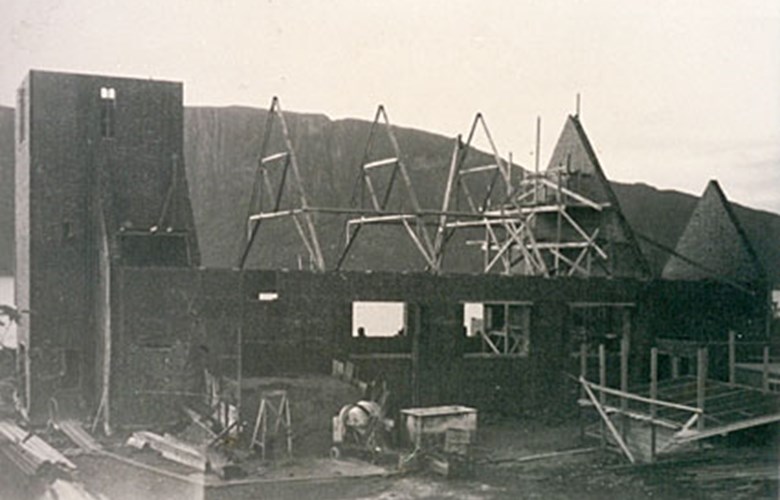 Frå bygginga av Øen kyrkje i Sørbøvåg. Bygginga starta i 1957 og 15. juni 1958 vart kyrkja vigsla. Her er skipet og tårnet komne på plass, og takstolane er i ferd med å bli monterte.
