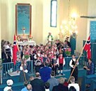 17. mai i Kjølsdalen kyrkje med barnekor og norske flagg. Presten held seg i bakgrunnen.

