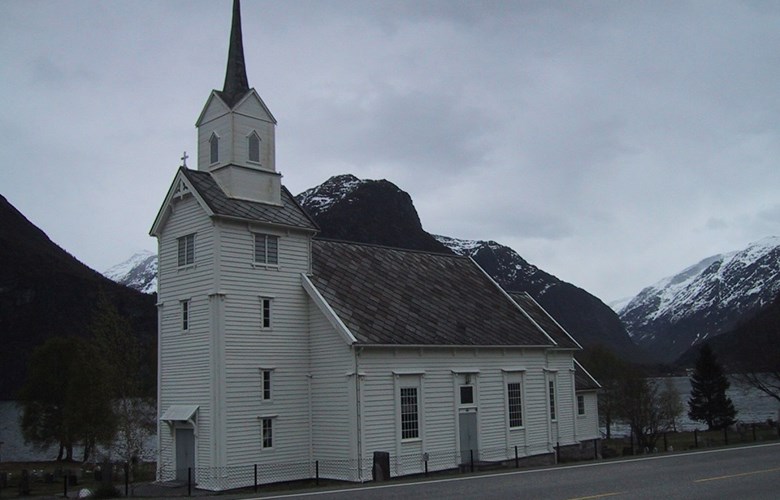 Oppstryn kyrkje ligg på garden Fosnes på sørsida av Strynevatnet.
