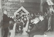 Alf Rosenlund dirigerer musikkorpset på kyrkjelemmen.
