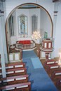 Frå interiøret i kyrkja. Vi ser koret med døypefonten, alteret, altertavla og preikestolen.
