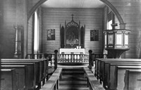Interiøret i kyrkja før 1926. Altertavla er den som Karl Uchermann måla til kyrkja i 1876, og som i 1926 vart erstatta av ei ny med same motiv. Nokre langsgåande benker står i midtgangen.