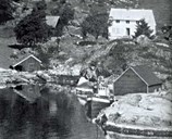 M/K "Erling" med kjenningsmerket SF-58-K (SF: Sogn og Fjordane, K: Kinn, kommune 1866-1964) ved naustet på heimegarden til foreldra til Adolf Skorpeide. Han hadde med sju flyktningar på turen over Nordsjøen i mai 1941. Båten vart rekvirert av den britiske marinen og vart mellom anna brukt som forsyningsbåt på marinebasen Scapa Flow på Orknøyane. Under invasjonen i Frankrike sommaren 1944 var "Erling" ein av dei mange båtane som plukka opp omkomne.<br />
"Erling" kom heim att til Norge hausten 1945. Første oktober stemnde båten inn til Bergen med same mannen ved roret som på turen vestover fire år tidlegare, Adolf Skorpeide.<br />
Båten vart sett i stand og var i bruk som fiskebåt til 1970.<br />
Legg elles merke til sitkagrana framfor huset. Ho kan vel her vera om lag ti år gammal og såleis datera biletet til fyrst på 1950-talet.