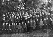 Elevar ved Innvik folkeskule 1905 med nasjonalflagget i bakgrunn.