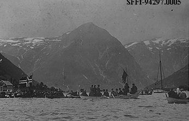 Balestrand den 13. august 1905: Mange menneske er samla på fjorden i samband med folkerøystinga i Tjugum kyrkje der ein skulle seia ja eller nei til unionen. Robåtane er fulle av festkledde kvinner og menn. 