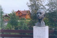 Byste av grunnleggjaren, Gert Falch Heiberg (1871-1944). I bakgrunnen Helgheimstova - den fyrste skulebygningen til Sogndal folkehøgskule frå 1874.