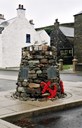 Minnesmerket Shetland Bus Memorial i Scalloway på Shetland. Det er bygd opp av stein frå stader som hadde tilknyting til Shetland Bus-operasjonane. I minnesmerket er felt inn fem plakettar med innskrift. På fire av dei står namna på dei 44 falne i Shetlandsgjengen.

