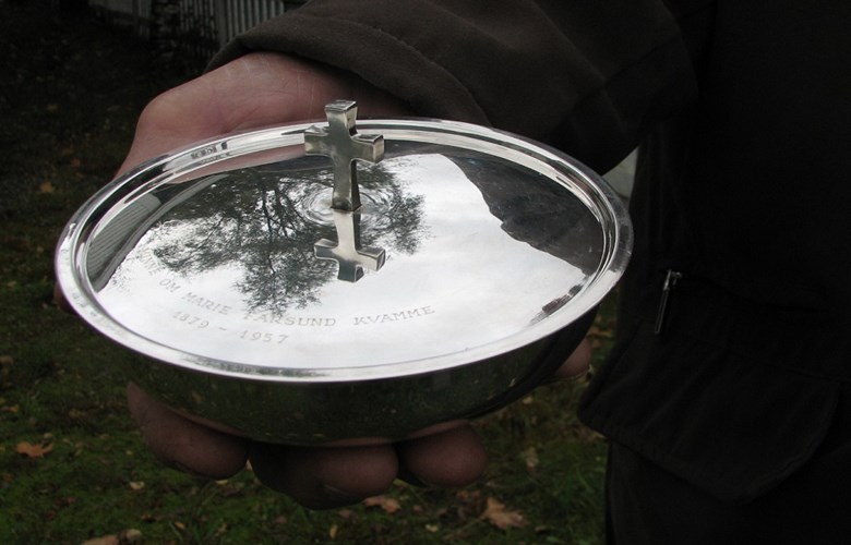 Sølvskåla har ein diameter på ca 16 cm og er ca 4 cm høg. Krossen på loket er omlag 2,5 cm høg. Skåla er laga av gullsmed David Andersen i Oslo.



