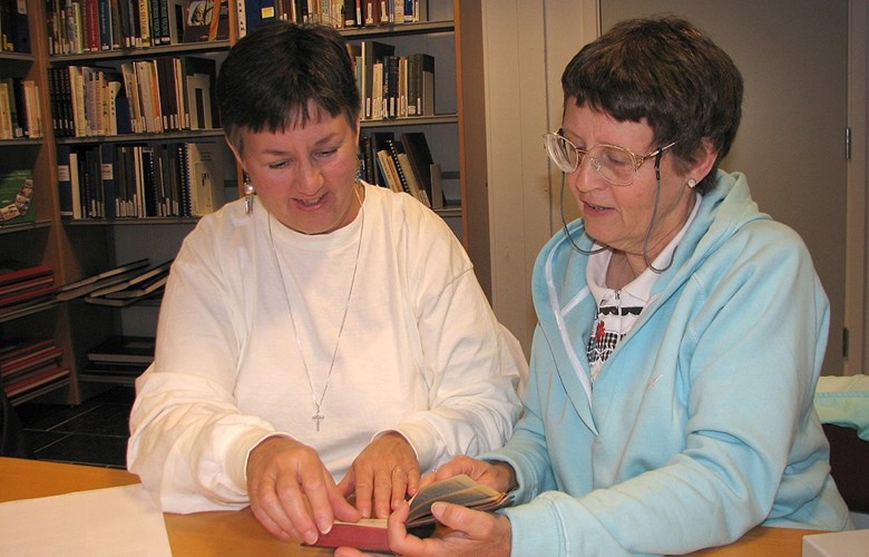 Systrene Roberta Trowbridge (t.v.) og Jeanne Mc Guire vitja Fylkesarkivet i juni 2006. Her ser dei i salmeboka som oldefaren, Olaf Huseby, gav ut i Kristiania i 1894. 




