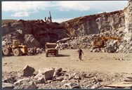 Steinen som vart nytta til å byggja Muravassdemninga med vart sprengd ut i nærleiken av demninga. Her ser me steinbrotet med boremaskin, dumpers, gravemaskin og hjullastar.
