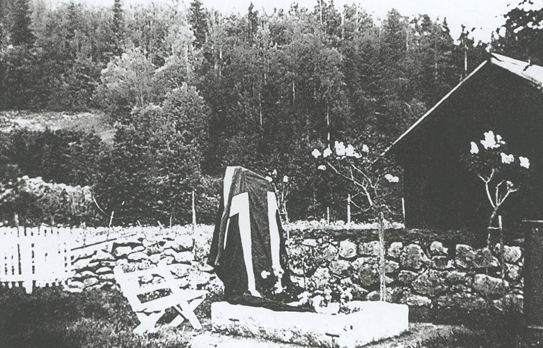 Minnesteinen på grava til Johan A. Berge, sveipa i det norske flagget før avdukinga.