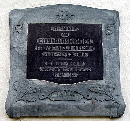 Bilete av minnetavla til Niels, her står det "Til Minde om Eidsvoldsmanden Provst Niels Nielsen / Født 1777. Død 1854. / Borgrund Kommune Satte Denne Mindetavle 17. Mai 1914."