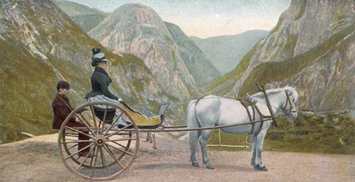 Bilete av eit postkort som viser karjol med hest, ein passasjer og skyssgut.