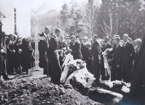 Bilete av båra til Aksel Midtkandal som blir sett ned i grava.