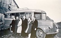Bussen til Henrik Myre som trafikkerte ruta mellom Raudeberg og Kvalheim. Her står Myre lengst til høgre i lag med dei to andre medeigarane i det fyrste buss-selskapet på Nord-Vågsøy, Kristian Kråkenes og Hjalmar Kvalheim, og konene deira.
