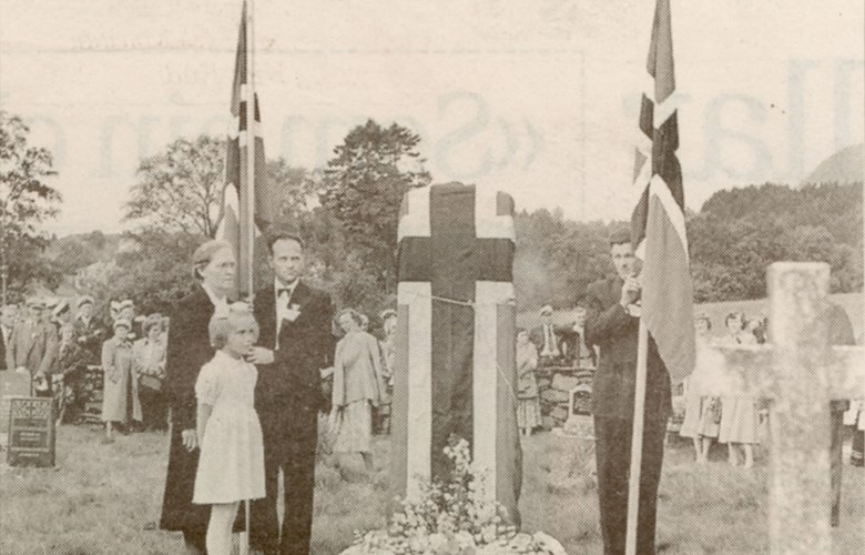 Minnesteinen sveipt i det norske flagget før avdukinga 14. juni 1953. Til venstre i flaggborga Leif Lien og Trygve Bjaanes. Dei to andre er fru Seri Espedal, f. Taksdal, og yngste dottera deira, Kari.