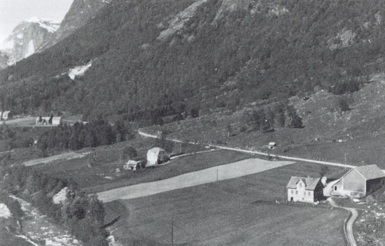 Flyfoto av dei fremste bruka på Langeteig. Elva renn like ved garden, og flaumen øydelagde i alt 35 mål åker og slåttemark på Langeteig 
