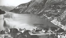 Rutebåten på veg ut Vadheimsfjorden tidleg på 1950-talet. Den store trebygningen til venstre er Vadheim Hotell som brann ned i 1961.
